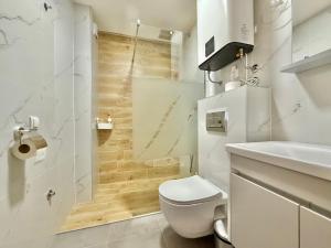 um banheiro branco com vaso sanitário e pia em Zlatibor Prestige Apartman 18 em Zlatibor