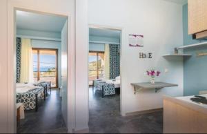 a kitchen and a living room with a view of the ocean at Loukia's apartment no 2 in Mesochórion