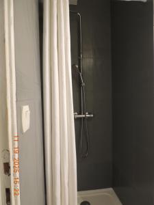 a shower with a white shower curtain in a bathroom at Les Coquelicots Chambre d' hote avec grand lit et salle d'eau privative pour une persone ou un couple in Vern-sur-Seiche