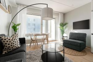 a living room with a couch and a table at Stylish, 450 m walk to the Estonian ferry, Free parking and balcony in Helsinki