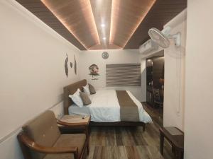a bedroom with a bed and a couch and a chair at Eastern Gate Homestay in Khajurāho