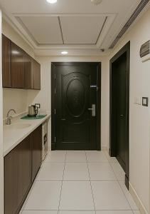 a kitchen with a black door in a room at فندق التاج ثلاثة مكة in Mecca