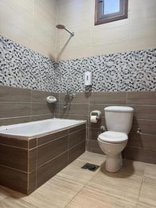 a bathroom with a bath tub and a toilet at Summer Land Hotel in Abu Simbel +72 photos