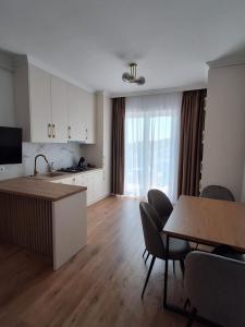 a kitchen and living room with a table and chairs at Apartament Suceava in Ipoteşti