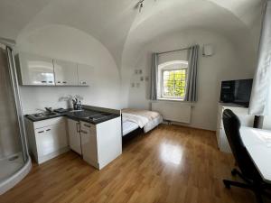 施泰尔Yellow House Apartments - Top 2的带水槽的厨房和房间里的一张床 更多6张照片