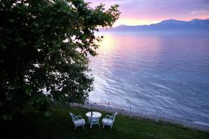 a table and chairs sitting next to the water at Ferienhaus Simos In Paleokastro in Edipsos