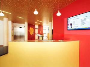 vestíbulo con barra y TV en la pared en ibis Styles Montpellier Centre Comedie, en Montpellier