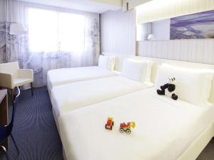 ein Hotelzimmer mit zwei Betten mit Spielzeugautos darauf in der Unterkunft Ibis Styles Roma Eur in Rom + 86 Fotos