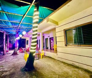 ein Gebäude mit einem Baum mit Licht in der Unterkunft The Village Retreat in Alībāg