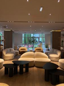 a large living room with couches and tables at Hôtel Alba in Lourdes