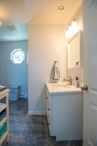 a bathroom with a sink and a mirror at Summer By The Sea Beach House in Saint Peters