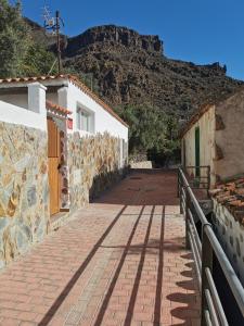 ein gemauerter Gehweg mit einem Berg im Hintergrund in der Unterkunft Casa El Alpendre de Temisas - Recién renovada in Temisas