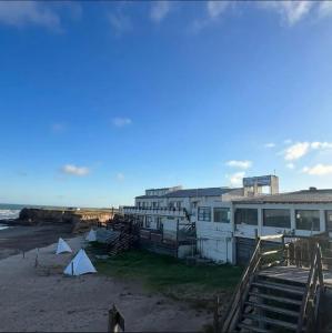 a building on the beach next to the ocean at Nuestro Eden II Playa Dorada in Playa Dorada