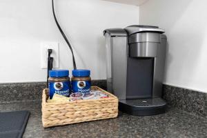 a basket of food and a coffee maker on a counter at Lovely Coach House in Langley with Queen Beds Pkg in Langley +3 photos