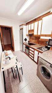 una cucina con tavolo e lavatrice di Jona Candás Asturias a Candás