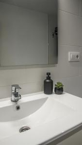 a white bathroom sink with a soap dispenser on it at Cal Perot Apartamento turístico en Les Borges Blanques in Les Borges Blanques  +23 photos