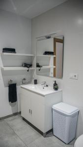 a white bathroom with a sink and a mirror at Cal Perot Apartamento turístico en Les Borges Blanques in Les Borges Blanques 