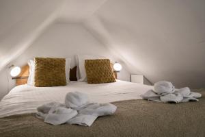 a bed with towels on it with two pillows at Le Petit Gîte - Confort & Elegance - Parking & WIFI - Calme & Jardin in Verlinghem +26 photos
