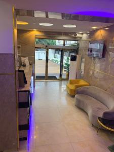 um átrio com sofás e uma televisão num quarto em Triple J Universal Hotel and Suites em Asaba