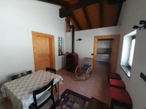 Zimmer mit einem Tisch, Stühlen und einer Tür in der Unterkunft Ginepro Verde Apartment in Lorenzago