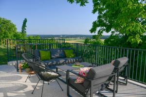 a patio with a couch and chairs on a fence at Vila Vinita in Sveti Jurij ob Ščavnici +31 photos