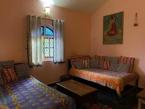 un salon avec un canapé et un lit dans l'établissement Anjuna Hideout, à Anjuna