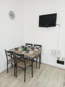 tavolo da pranzo con sedie e TV a schermo piatto di Apartament Royal a Şelimbăr
