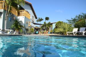 a swimming pool in front of a house at La Felicidad Aruba in Oranjestad