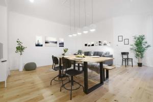 ein weißes Wohnzimmer mit einem Holztisch und Stühlen in der Unterkunft Gesamte Unterkunft Apartment in Ludwigslust in Ludwigslust + 12 Fotos