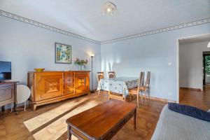 Appartement Tout Confort في ليه ليكيه: غرفة معيشة مع طاولة وغرفة طعام