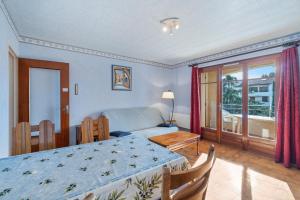 Appartement Tout Confort في ليه ليكيه: غرفة نوم بها سرير وطاولة ونافذة