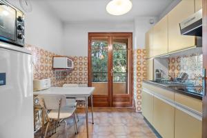 Appartement Tout Confort في ليه ليكيه: مطبخ مع طاولة وكراسي وباب