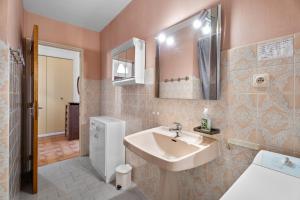 Appartement Tout Confort في ليه ليكيه: حمام مع حوض ومرآة +13 صورة