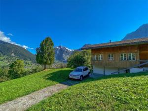 ein vor einem Haus geparktes Auto in der Unterkunft Ferienhaus Chalet Simeli in Grindelwald