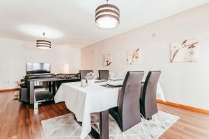 ein Esszimmer mit einem Tisch und einem Klavier in der Unterkunft Modern & Elegant 2 bedroom in Amadora by GT House in Amadora