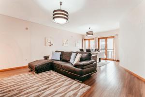 ein Wohnzimmer mit einer Ledercouch und einem Tisch in der Unterkunft Modern & Elegant 2 bedroom in Amadora by GT House in Amadora