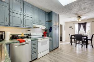 a kitchen with green cabinets and a dining room at Easy Hwy Access to ATL Work-Ready Riverdale Home in Riverdale