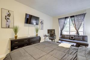 a bedroom with a large bed and a flat screen tv at Easy Hwy Access to ATL Work-Ready Riverdale Home in Riverdale