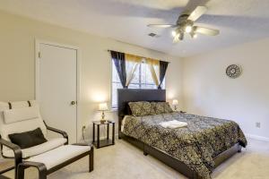a bedroom with a bed and a chair and a ceiling fan at Easy Hwy Access to ATL Work-Ready Riverdale Home in Riverdale