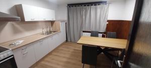 een keuken met een houten tafel en een houten aanrecht bij KaTi Hiša  +7 foto's