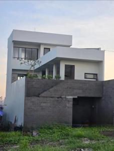 une grande maison blanche avec un mur en béton dans l'établissement Verdana Cemagi Luxury Hostel, à Cemagi