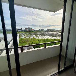 un balcon avec vue sur une rizière dans l'établissement Verdana Cemagi Luxury Hostel, à Cemagi