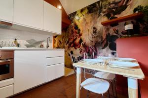 a kitchen with a table with white cabinets at Le Petit Gîte - Confort & Elegance - Parking & WIFI - Calme & Jardin in Verlinghem