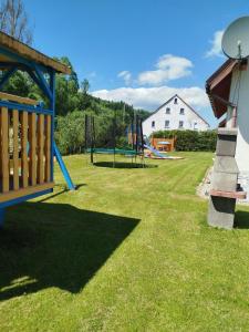 einen Hof mit einem Spielplatz mit Rutsche in der Unterkunft PRZYSTAŃ NAD BOBREM z Balią i Sauną in Kamienna Góra