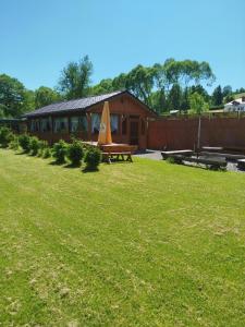 ein Gebäude mit einem Picknicktisch in einem Hof in der Unterkunft PRZYSTAŃ NAD BOBREM z Balią i Sauną in Kamienna Góra