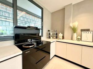 eine Küche mit einem schwarzen Herd und einem Fenster in der Unterkunft NEW Luxury 6BR Pool Villa Pattaya, 10mn Walking St in Jomtien Beach