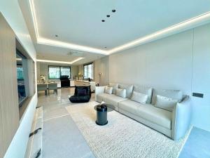 ein Wohnzimmer mit einer weißen Couch und einem Tisch in der Unterkunft NEW Luxury 6BR Pool Villa Pattaya, 10mn Walking St in Jomtien Beach