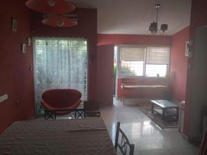 ein Wohnzimmer mit roten Wänden, einem Tisch und einem Klavier in der Unterkunft Chalet y rio in Villa Carlos Paz