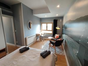 a living room with a bed and a chair at OFERTA ESPECIAL ÚLTIMA HORA - SARAKATUA15 - vistas espectaculares - familias y parejas - 2 dormitorios independientes - amplio salón cocina comedor - tarjeta parking OTA GRATIS - Julio y agosto estancia mínima 7 noches de domingo a domingo - in Zarautz