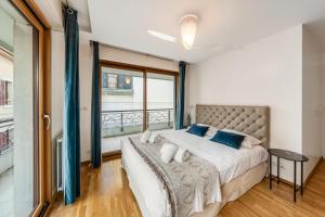 a bedroom with a large bed and a large window at La Coupole in Évian-les-Bains